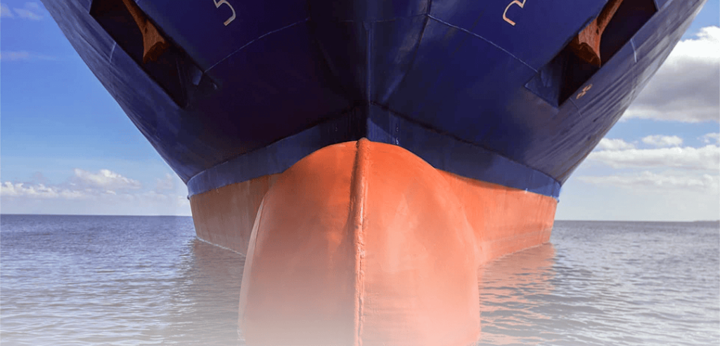 Vista frontal da proa de um navio cargueiro com destaque para o bulbo de proa vermelho submerso