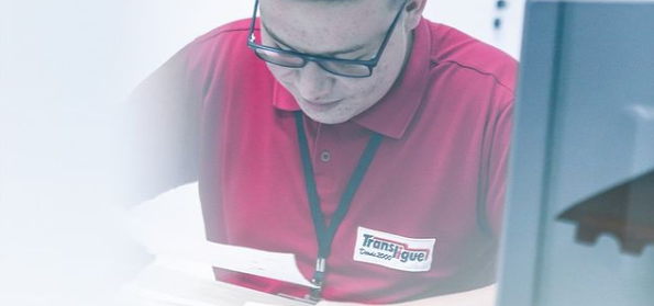 Funcionário da Translingue com uma camiseta vermelha com a logo da Transligue. 